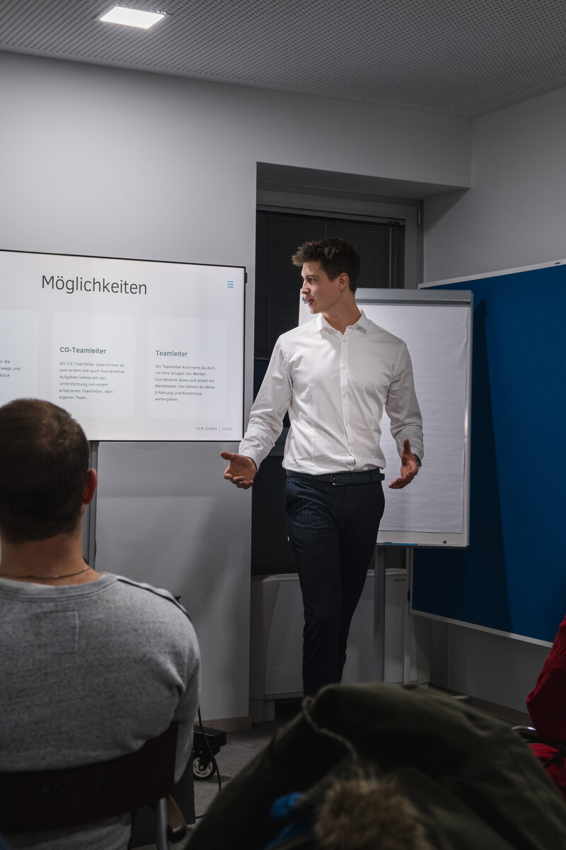 Ein Trainer präsentiert einer Gruppe die Möglichkeiten einer Spendenkampagne.